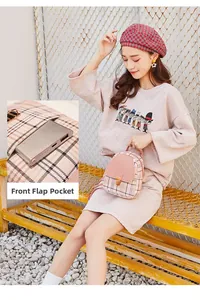 Detail view of pink plaid backpack featuring a functional front flap pocket with metal clasp