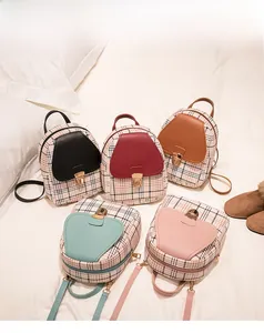 Collection of plaid patterned backpacks in various colors displayed on a white bed
