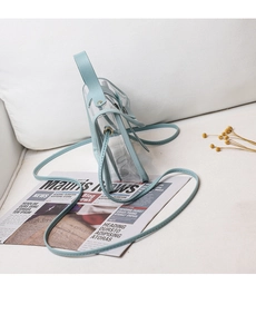 Detail view of transparent PVC shoulder bag with light blue trim and gold metal rivets