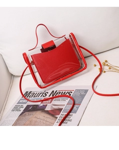 Close-up of red transparent PVC mini crossbody bag on beige fabric surface with decor