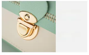 Detail of mint green and beige contrast bag with gold hardware lock and stitching