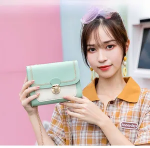 Detail of mint green crossbody bag featuring metal buckle and chain strap