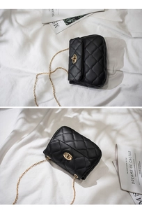 Detail view of black quilted leather crossbody bag with gold metal clasp and chain strap