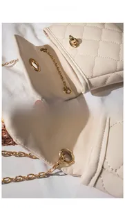 Detail of golden turn-lock closure and beige quilted leather on a crossbody bag