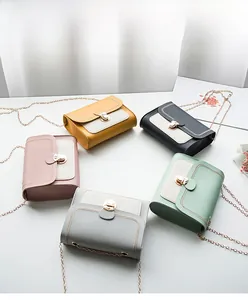 Flat lay of five mini crossbody bags in assorted colors with gold metal locks and chains