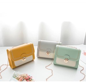 Three mini chain shoulder bags in yellow, grey, and green with chic color blocking design