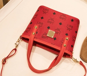 Detail der roten Monogramm-Beuteltasche mit goldfarbenen Metallteilen und Lederstruktur