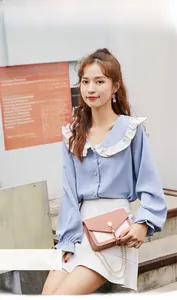Blue chiffon shirt with white ruffled collar paired with a pink crossbody phone bag