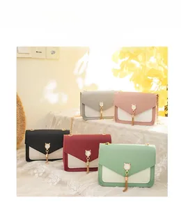 Detailed view of mini color-block crossbody bags with cat ear buckles and metal tassels