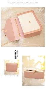 Detail view of pink and white color block crossbody bag with gold chain and magnetic buckle