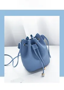 Detail of blue bucket bag showing lychee pattern leather and metal ball drawstring