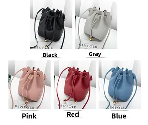 Detail of five colored drawstring bucket bags in black grey pink red and blue leather
