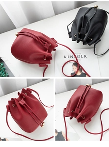 Detail of minimalist bucket bag with litchi grain texture and metal bead drawstring
