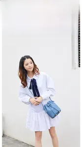 Blue lychee leather bucket bag with drawstring and golden studs worn as a crossbody bag