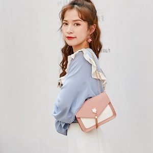 Pink and white crossbody bag with cat ear metal ring and chain strap on a model