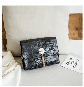 Dettaglio borsa nera texture coccodrillo con fibbia a margherita e catena d'oro