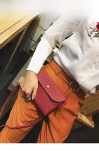 Detail of red litchi texture PU leather mini crossbody bag with gold snap button