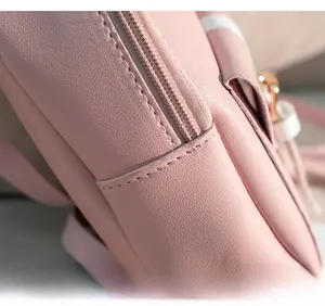 Dettaglio delle cuciture fini e della cerniera dorata sullo zaino in pelle rosa