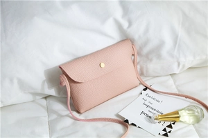 Detailed close-up of pink litchi grain PU leather crossbody bag with golden clasp