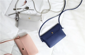 Detailed macro view of minimalist PU leather crossbody bags in white, blue, and pink colors