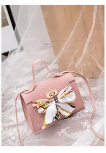 Detailed shot of pink lychee leather handbag with golden lock and printed silk scarf