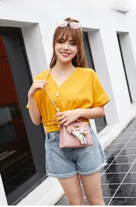 Pink lychee grain handbag with silk scarf detail styled with yellow blouse and denim