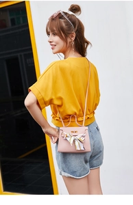 Pink lychee texture handbag with silk scarf and adjustable strap shown on model outdoors