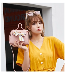 Pink lychee grain handbag with silk scarf detail worn with a yellow dress