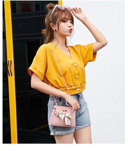 Pink lychee texture crossbody bag with silk scarf detail and golden lock shown on a model