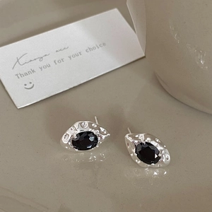 Macro view of vintage black zircon stud earrings with silver hammered metal finish