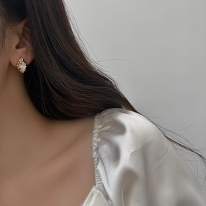 Vintage gold-plated earrings with marquise-cut crystal on a model wearing silk shirt
