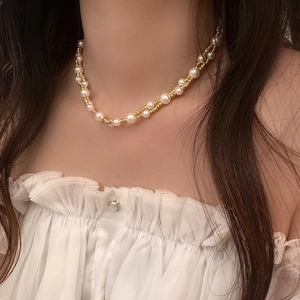 Detail of double-layer pearl and gold bead necklace worn with a white strapless top