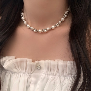 Detail of double-layer necklace with elegant pearls and twisted silver metal chain