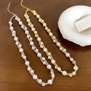 Detail of gold and silver double-layered necklaces with twisted pearl and spiral chain