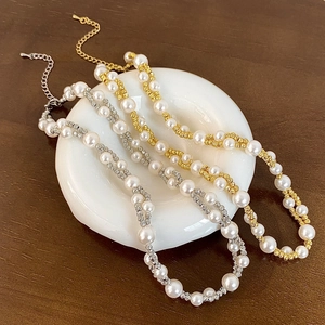 Elegant double-layer pearl necklace with gold finish on a white ceramic plate