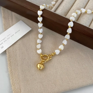 Detail of beaded heart necklace with natural mother-of-pearl and gold toggle clasp