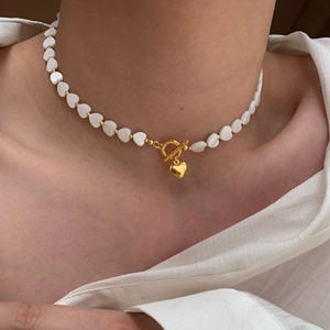 French style mother of pearl heart bead necklace with gold T-bar clasp on a model