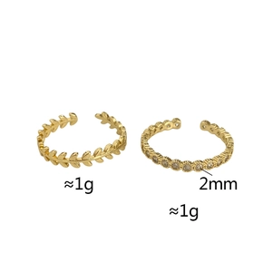 Detail of two gold-plated adjustable rings with zircon leaf and slim pave band designs