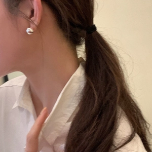 Minimalist polished silver bean stud earrings for women shown on a model side profile