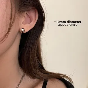 Detail shot of a 10mm silver-plated ball stud earring shown on a model's ear