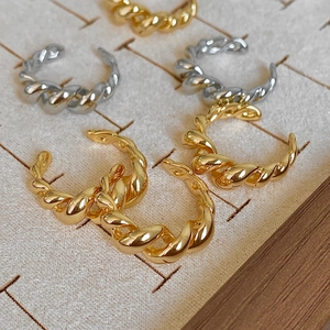 Macro detail of twisted croissant style rings in polished gold and silver plating