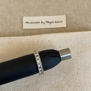 Gros plan d'une bague d'éternité dorée sertie de zircons cubiques de coupe carrée