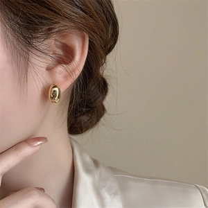 Elegant gold bean-shaped stud earrings featuring a smooth polished minimalist metal finish