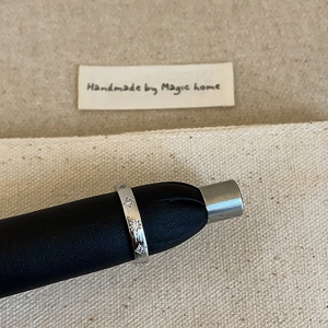 Détail macro d'une bague argentée avec texture brossée et zircons gravés en étoile