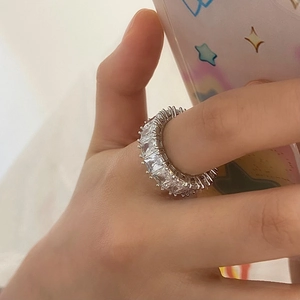 Macro detail of silver eternity ring with square-cut cubic zirconia on a hand
