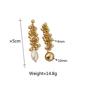 Detail view of asymmetrical golden tassel earrings with freshwater pearl and dimensions