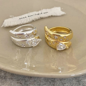 Détail d'une bague ajustable avec zircon cubique poire et étoiles sur un plateau