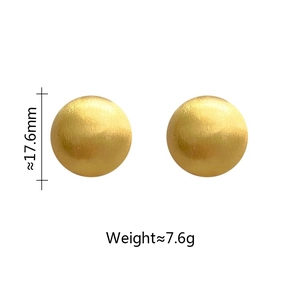 Detailed view of 17.6mm gold round stud earrings with a brushed metal matte texture