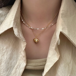 Double-layered gold heart pendant necklace with shimmering silver beads for women