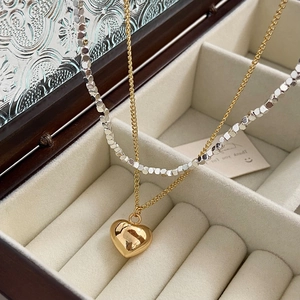 Double-layer gold and silver mixed heart pendant necklace on beige velvet jewelry box